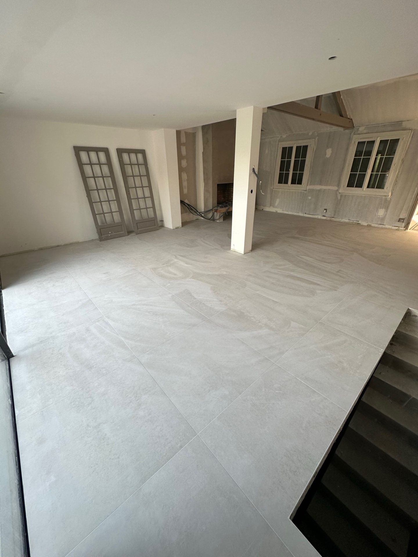 Pièce de vie rénovée avec carrelage clair grand format rectifié