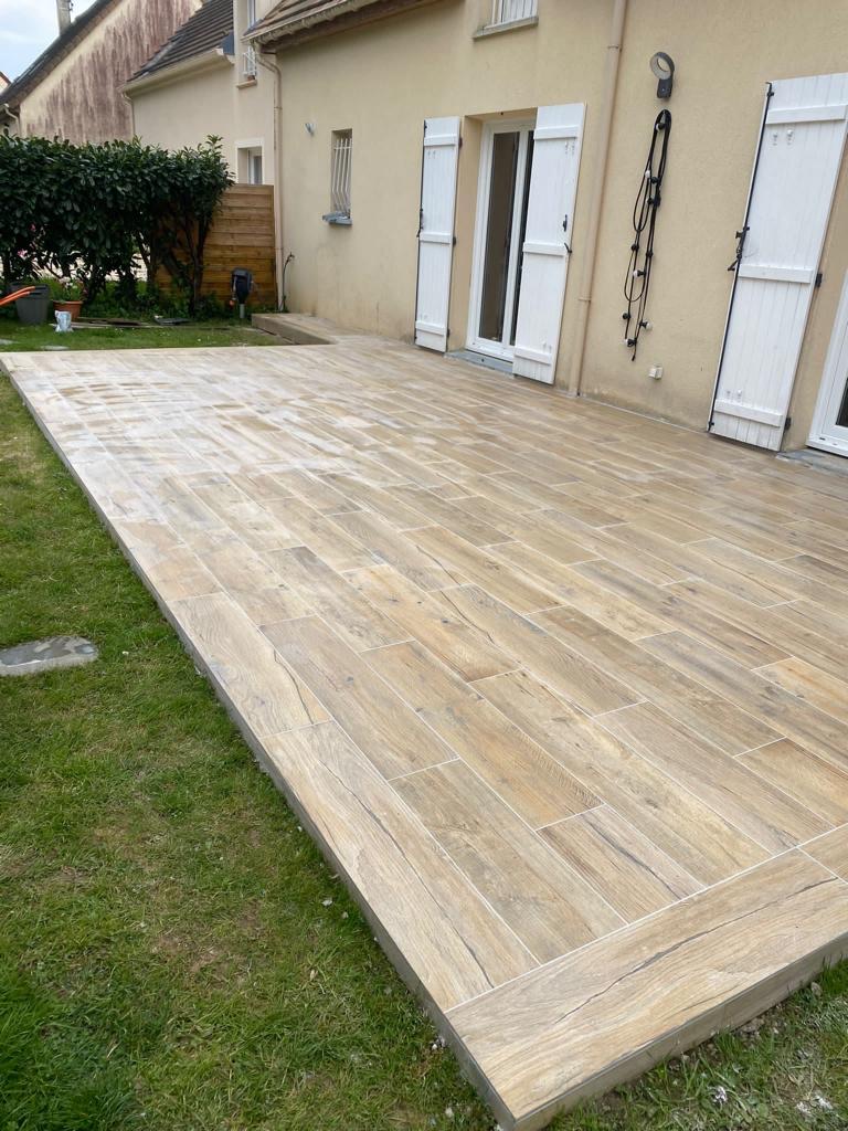 Terrasse carrelée imitation bois avec finitions soignées en maison individuelle