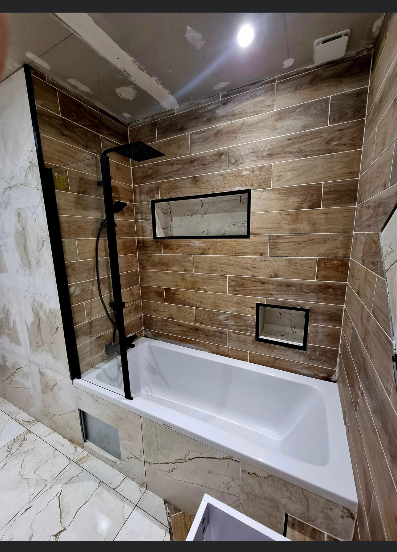 Salle de bain carrelée avec faïence effet marbre et éléments bois réalisée par Car Sol