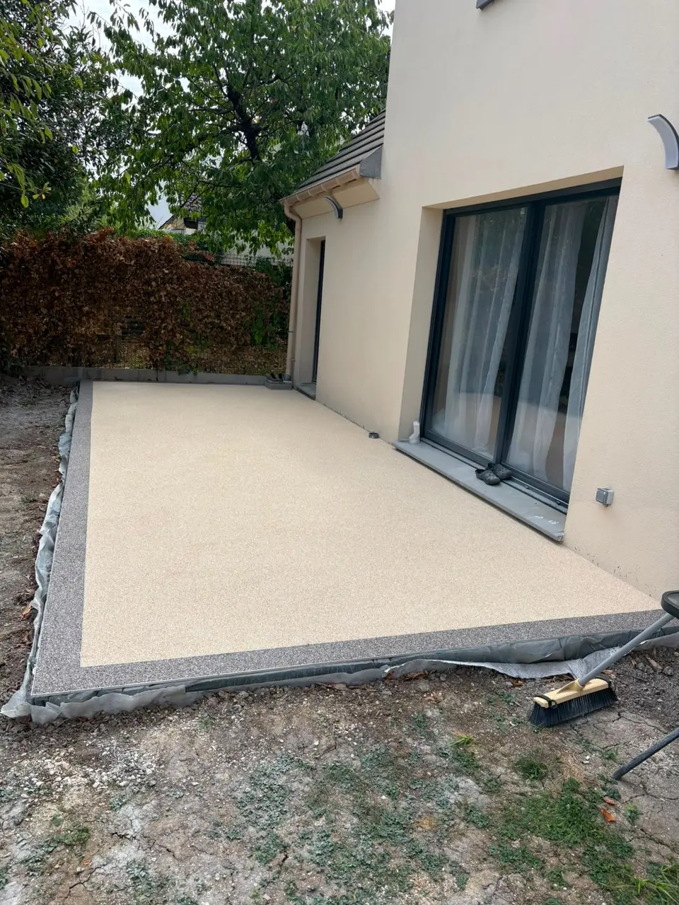 Après la pose : terrasse beige en moquette de pierre avec bordure grise à Noisy-le-Grand
