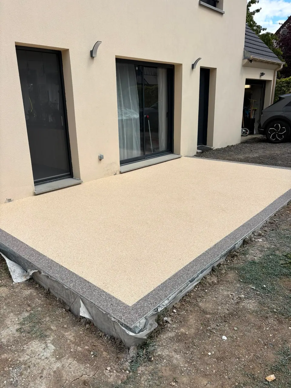 Terrasse en moquette de pierre beige avec bordure grise réalisée par Car Sol à Noisy-le-Grand (93)