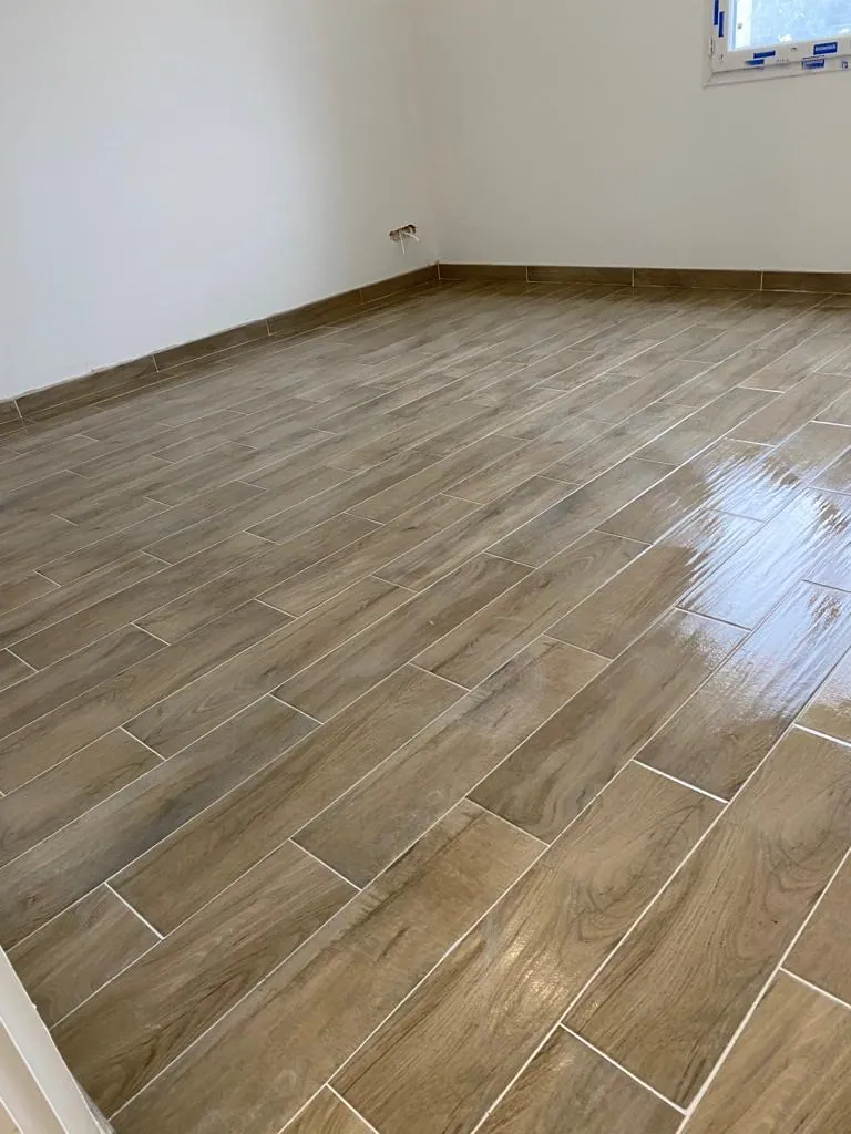 Pièce de vie avec lames céramiques effet bois posées en bâton rompu
