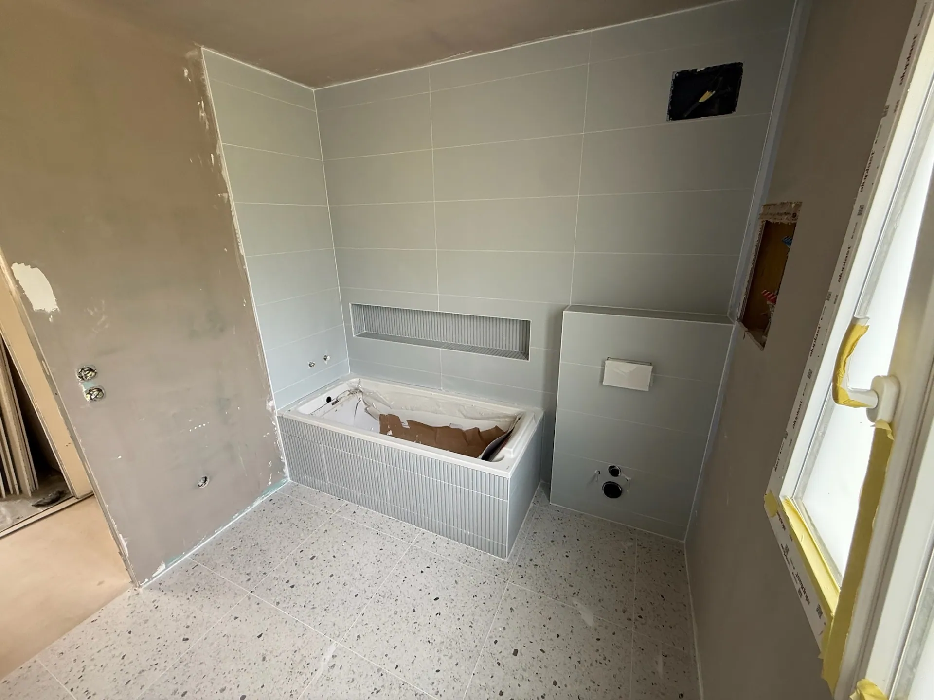 Faïence murale posée du sol au plafond dans une salle de bain familiale